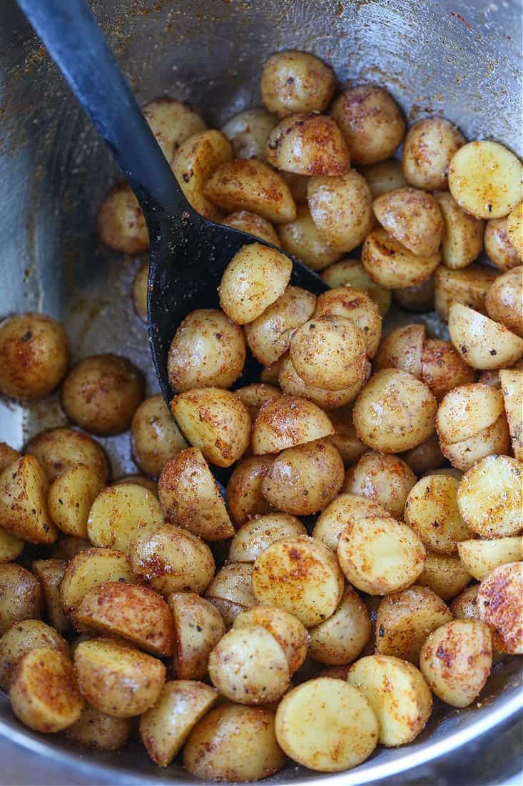 baby potatoes mixed with seasonings in a bowl
