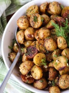 Garlic Dill Roasted Potatoes in a white bowl with spoon