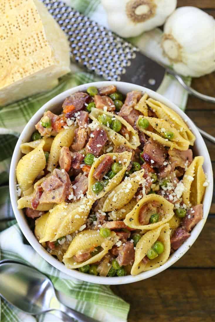 Pasta with Ham and Peas in a bowl with parmesan cheese