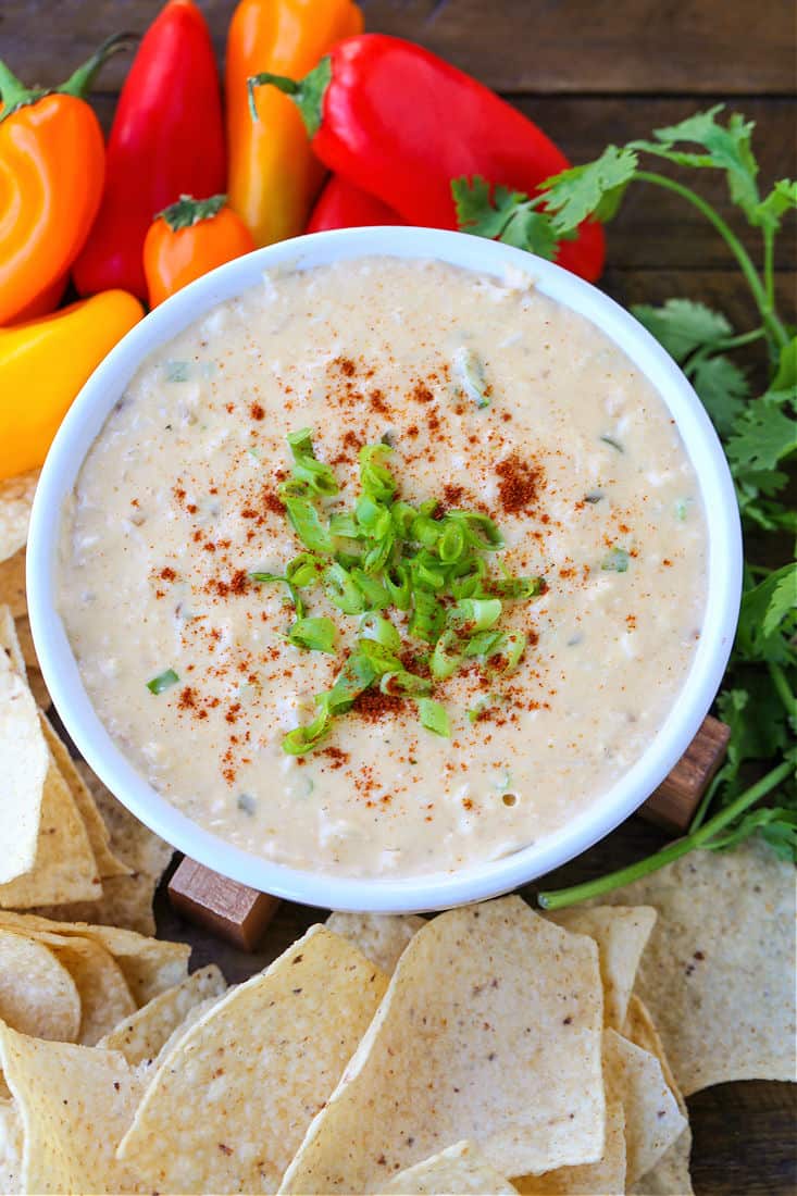 Hot crab dip served with tortilla chips and mini peppers