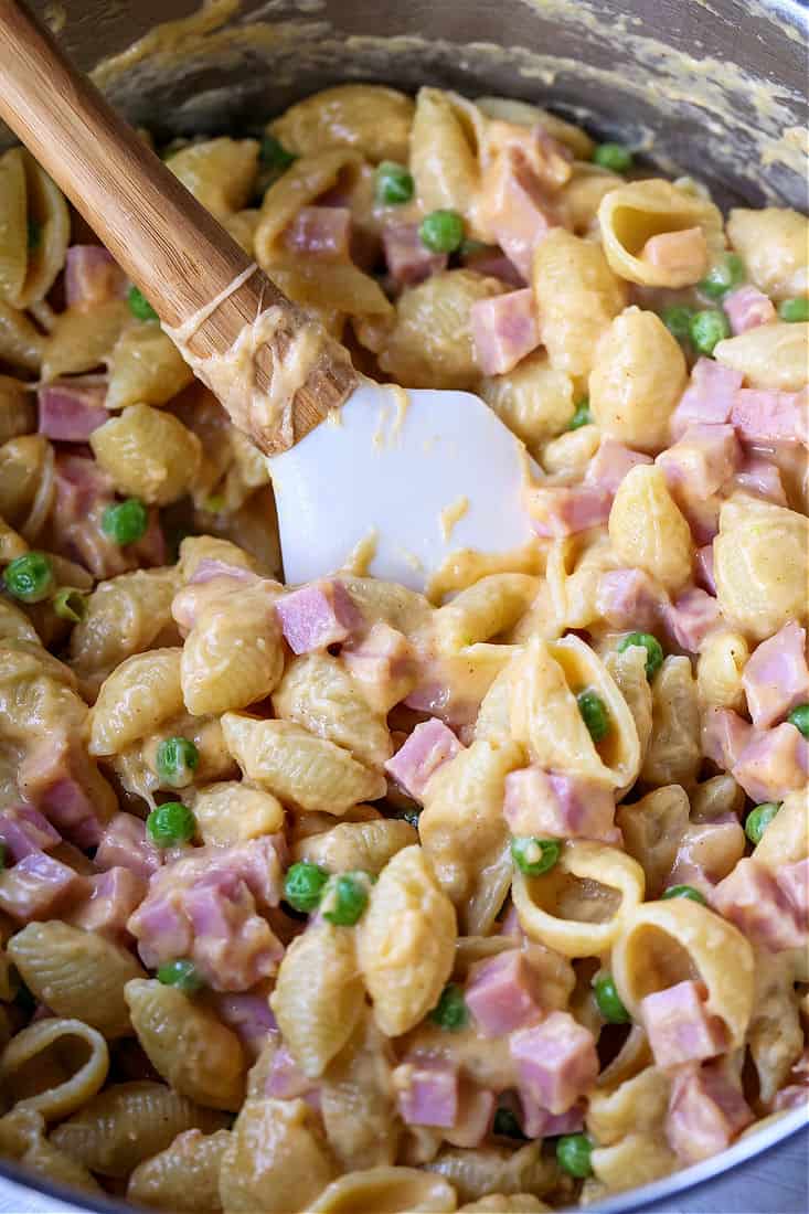 Shells with cheese and diced ham and peas