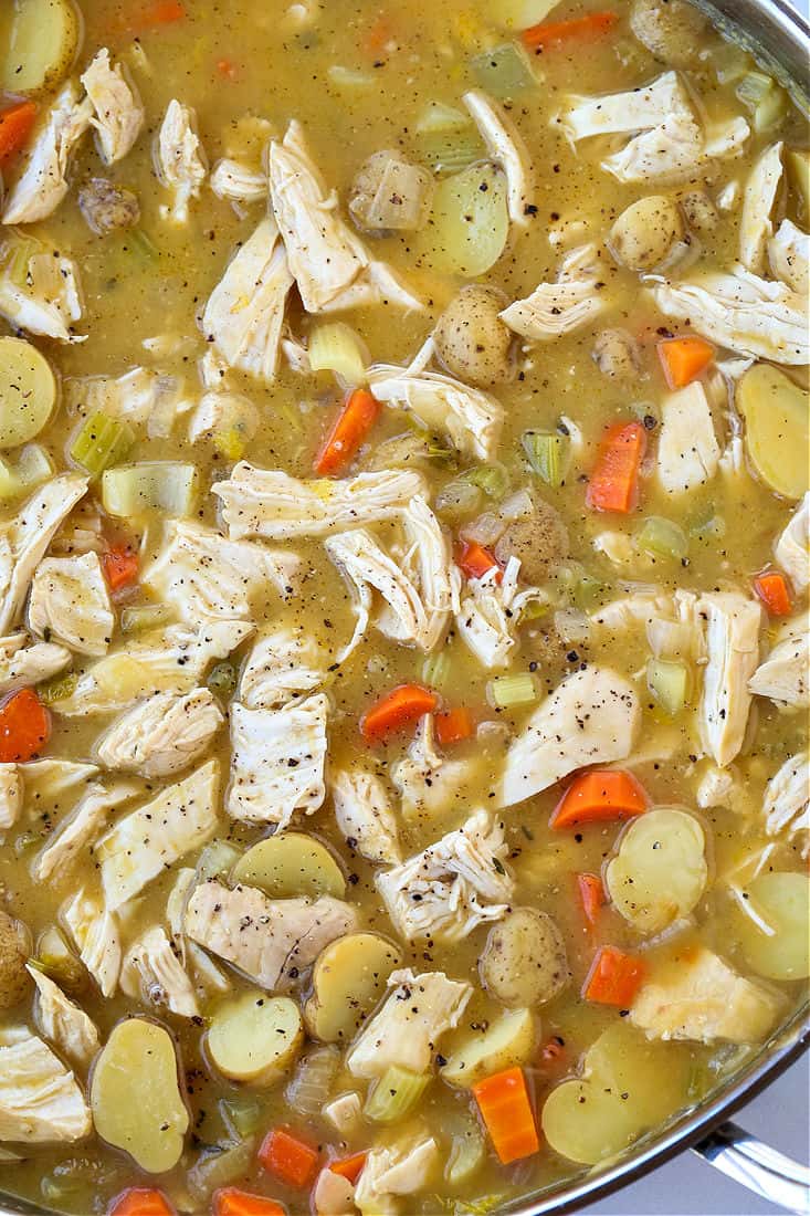 Shredded chicken in broth with potatoes and fresh herbs