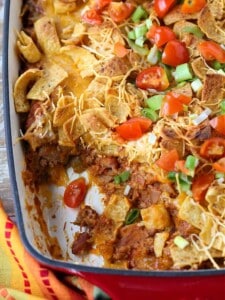 Frito Pie in a baking dish with a scoop taken out