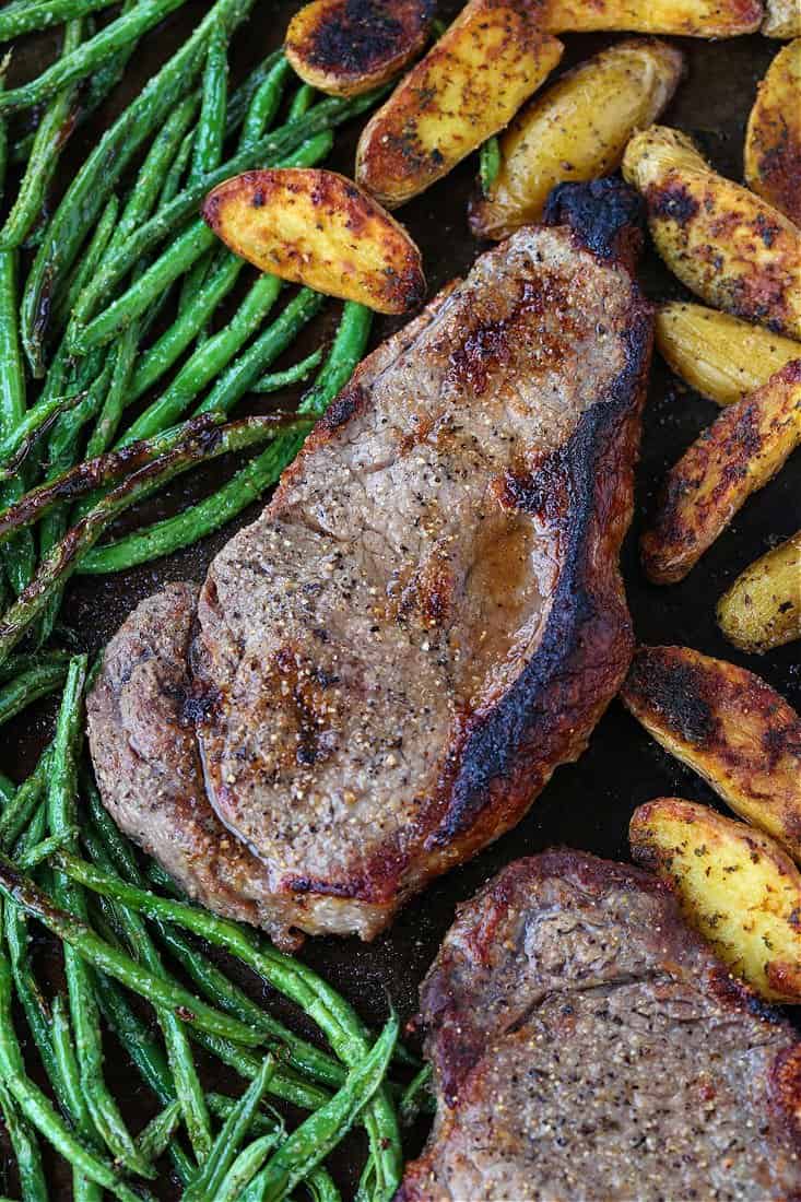 This Steak Sheet Pan Dinner is an easy and delicious way to enjoy a steak dinner at home! Everything cooks on one pan so clean up is a breeze! Sheet Pan Steak Dinner on a baking sheet after cooking