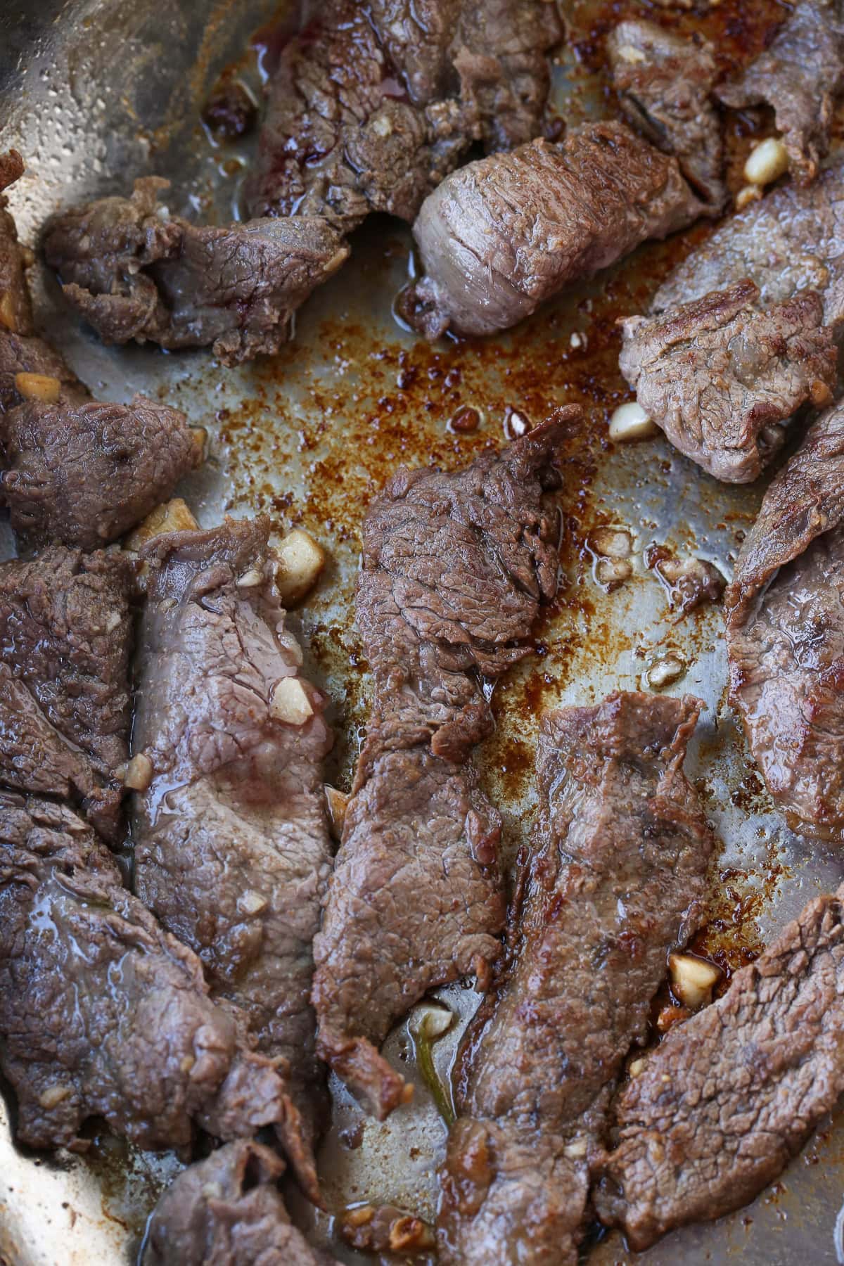 Our Steak Fajita Recipe turns any night into a party! Marinated flank steak with charred, sweet peppers and onions piled into warm tortillas. sliced steak in skillet