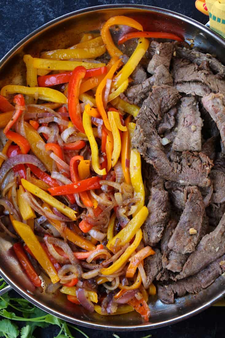 Peppers and steak in a skillet for steak fajitas
