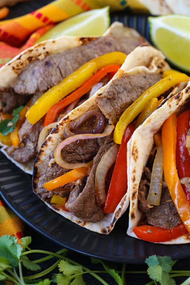 Steak Fajitas on a plate with colorful napkin and limes