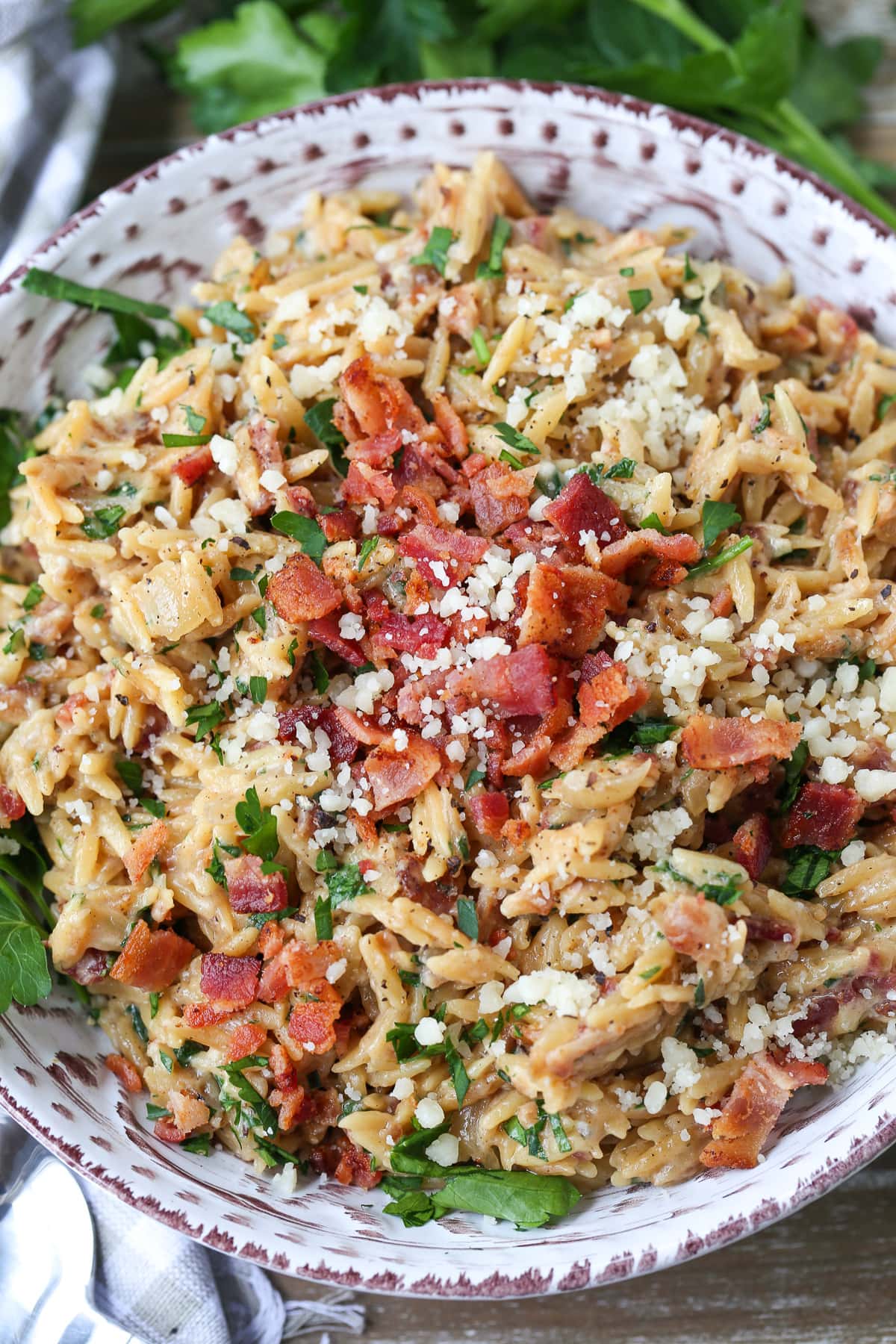 orzo recipe with bacon and parmesan cheese in grey bowl
