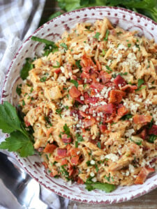 orzo with parmesan cheese and bacon in bowl with parsley
