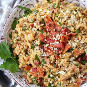 orzo with parmesan cheese and bacon in bowl with parsley