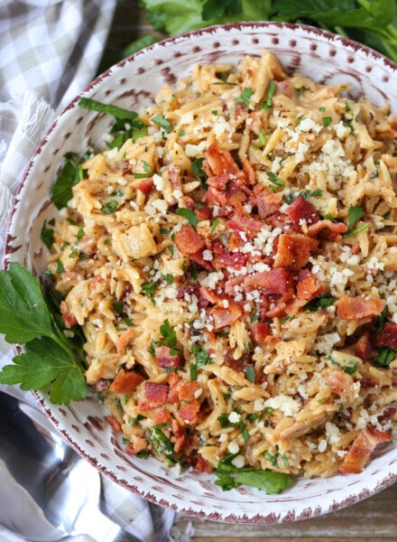 orzo with parmesan cheese and bacon in bowl with parsley