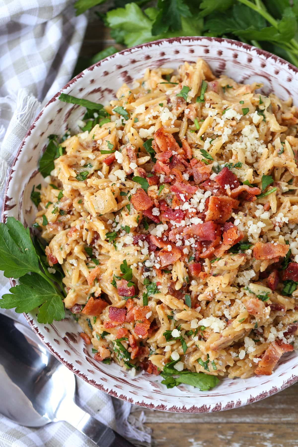 orzo with parmesan cheese and bacon in bowl with parsley