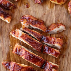 sliced chicken thighs with barbecue sauce on a board