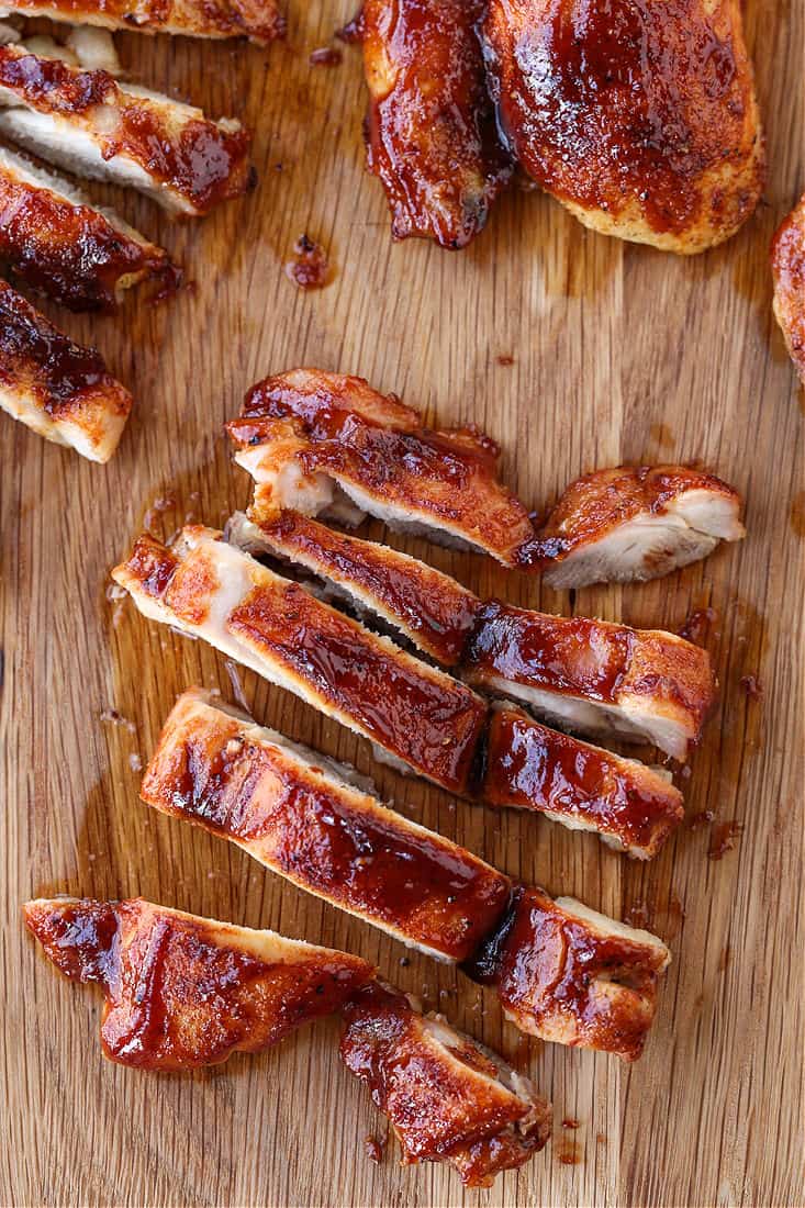 sliced chicken thighs with barbecue sauce on a board