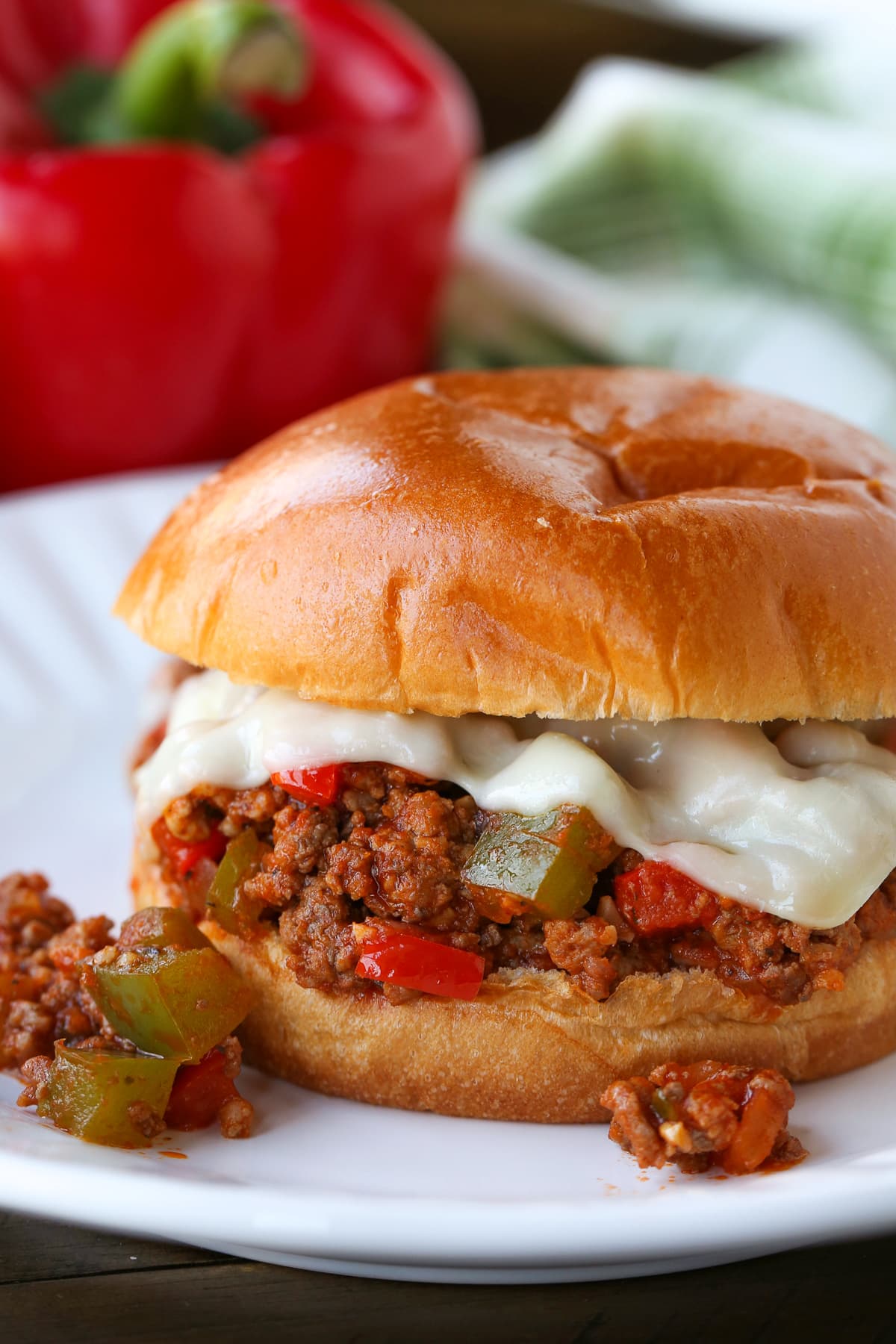 sloppy joe sandwich with cheese on white plate