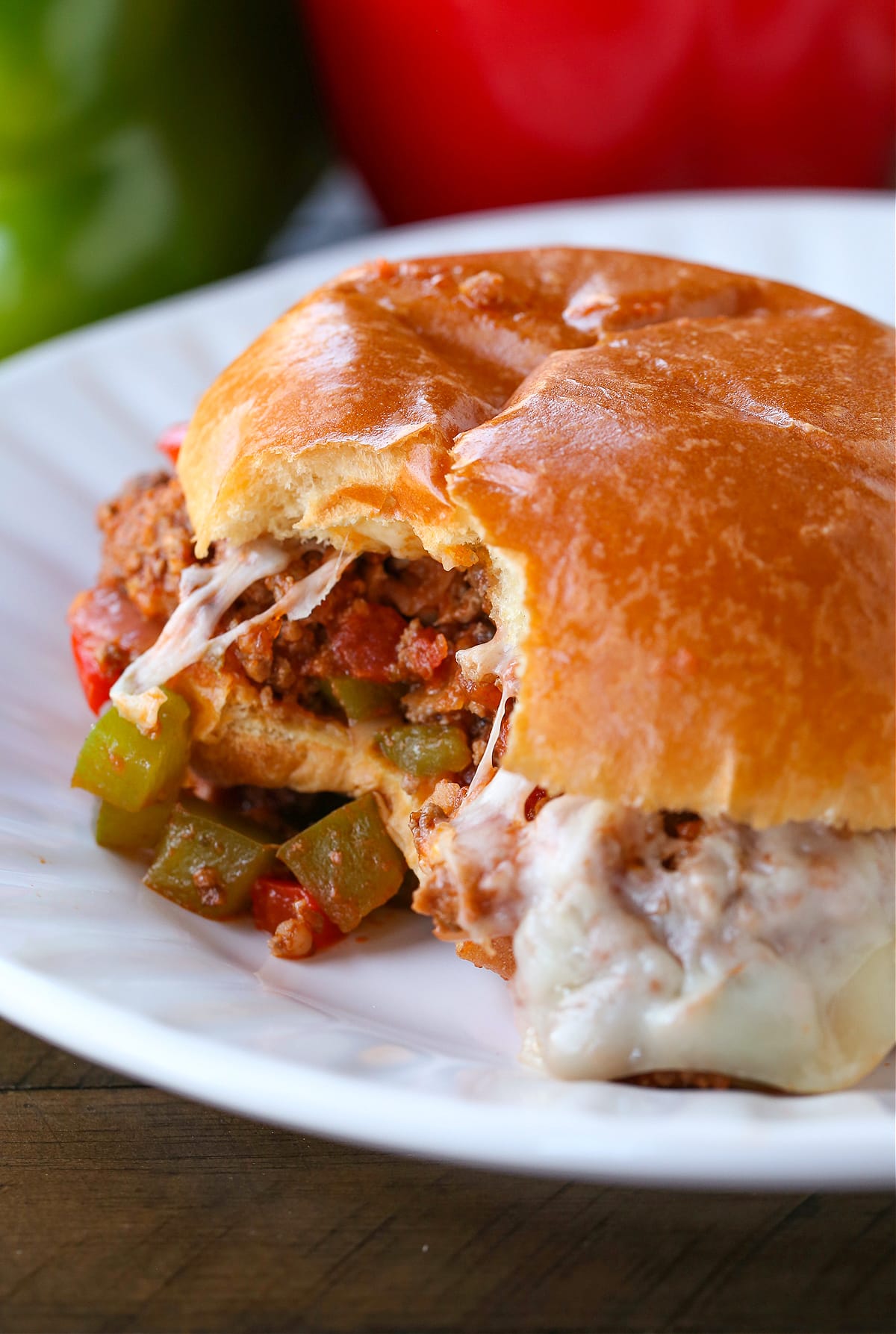 Italian Sloppy Joes are an easy dinner recipe that everyone loves! An Italian twist to a sloppy joe with peppers, onions and melted cheese! sloppy joe sandwich with bite taken out