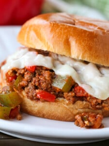 sloppy joe sandwich with melted mozzarella cheese on plate