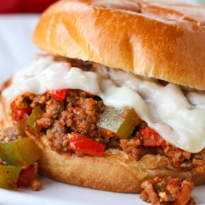 sloppy joe sandwich with melted mozzarella cheese on plate