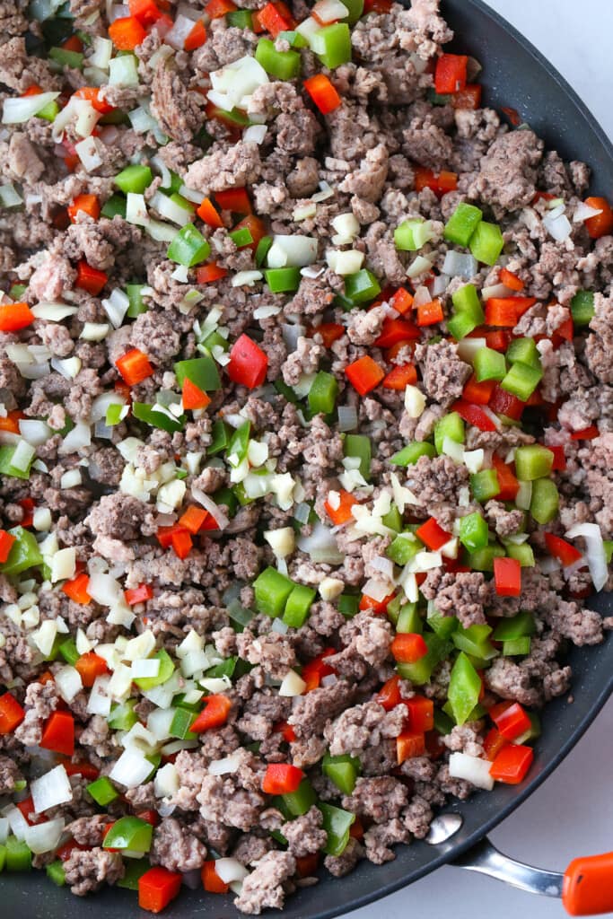 ground beef, peppers and onions in a skillet