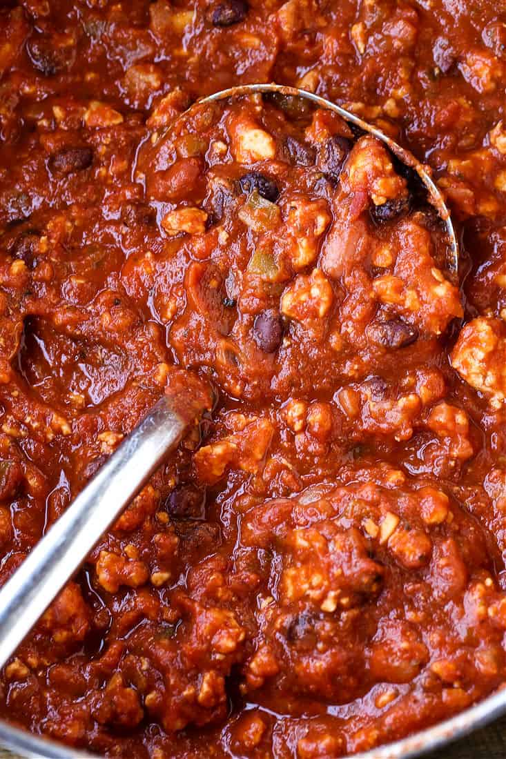 Chicken chili in a pot with ladle