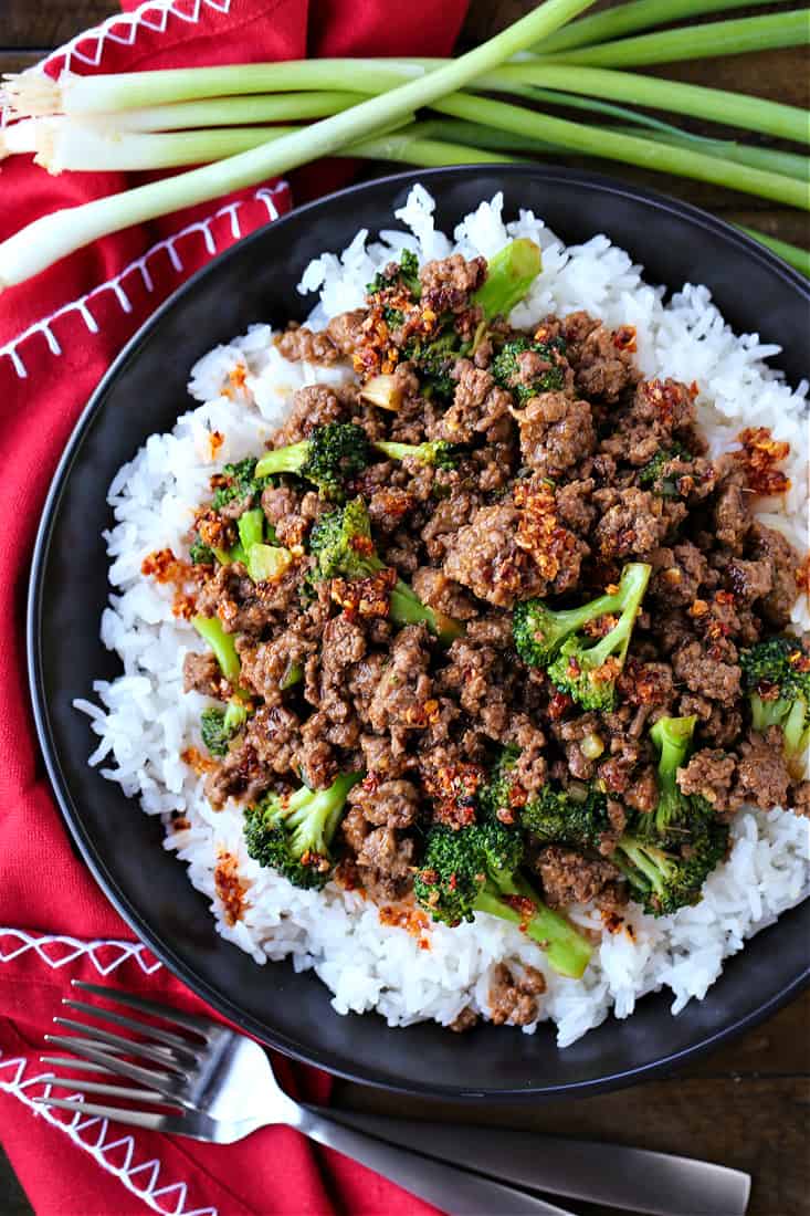 Ground beef and broccoli on a bed of rice on a black plate
