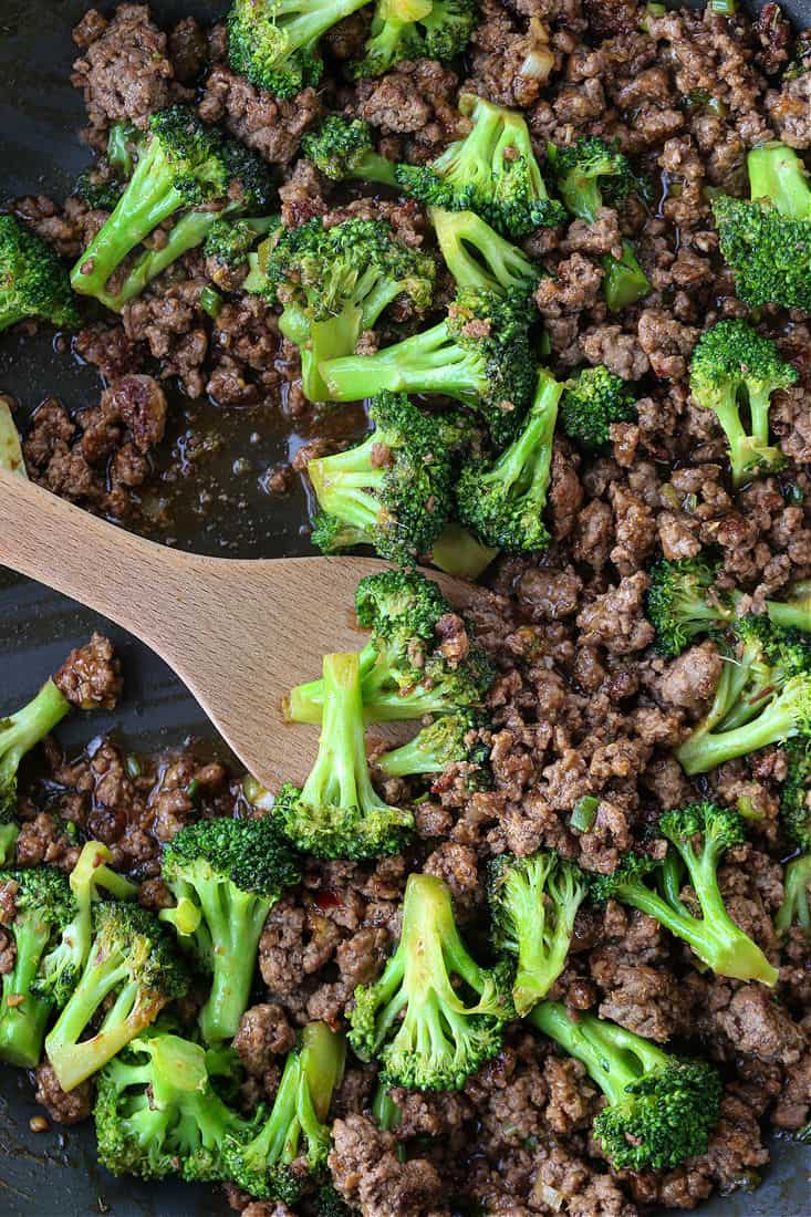 Ground Beef and Broccoli in a skillet with wooden spoon