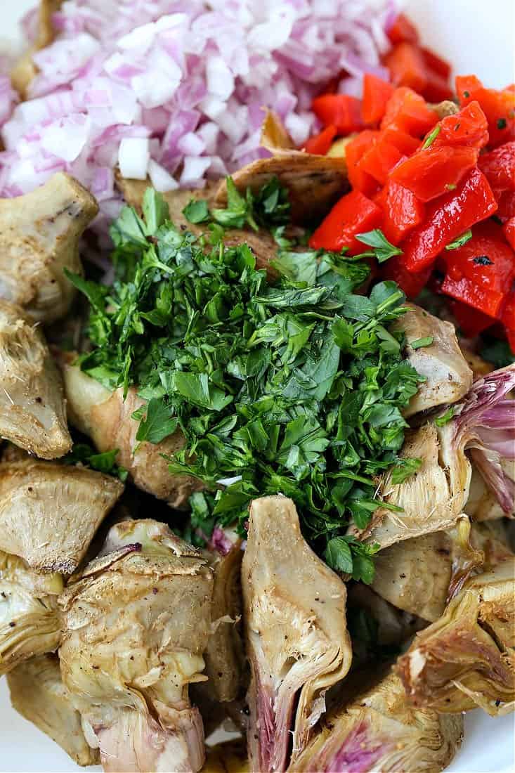 Ingredients to make roasted artichoke salad in a bowl