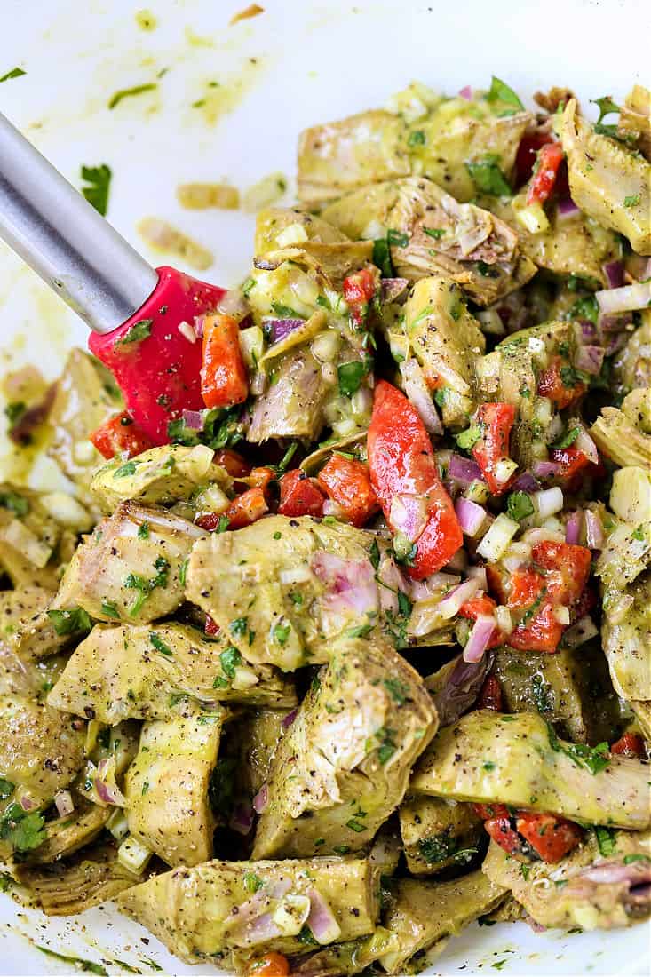 A salad made with roasted artichoke hearts, roasted red peppers and onions