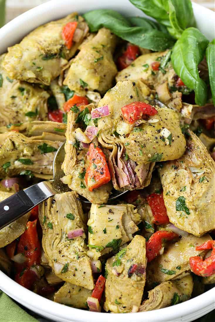 Roasted Artichoke Salad in a bowl with serving spoon