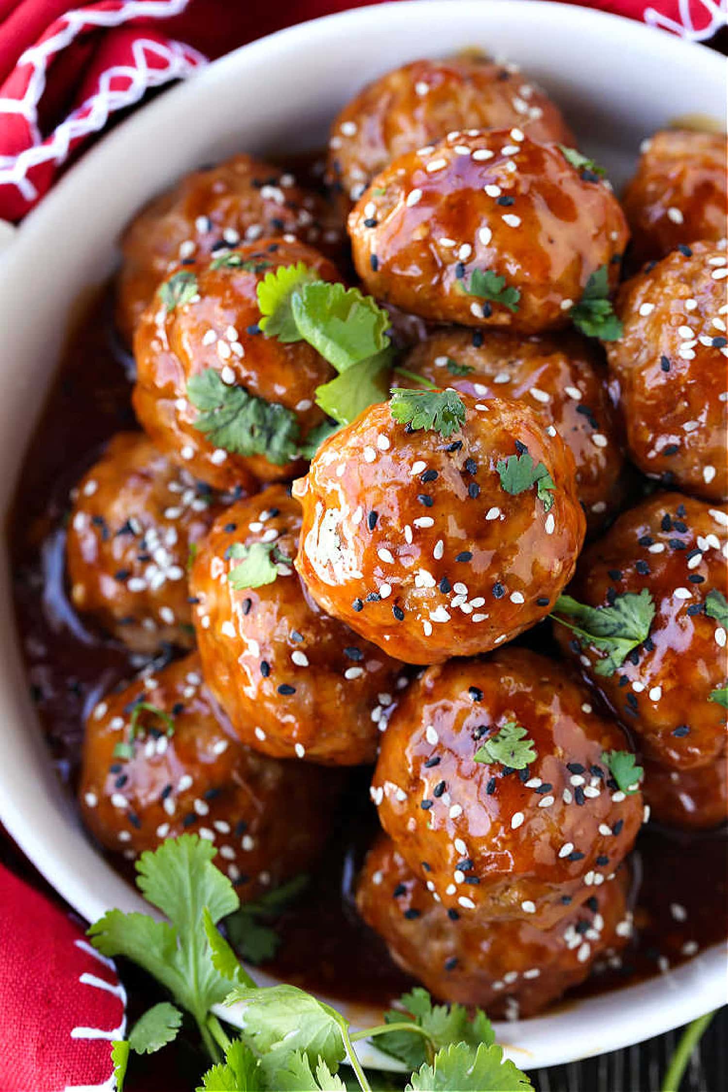 This Teriyaki Meatball recipe is one of our favorite, easy to make dinners! Oven baked, flavorful meatballs tossed in a teriyaki glaze! Teriyaki Meatballs in a bowl with red napkin