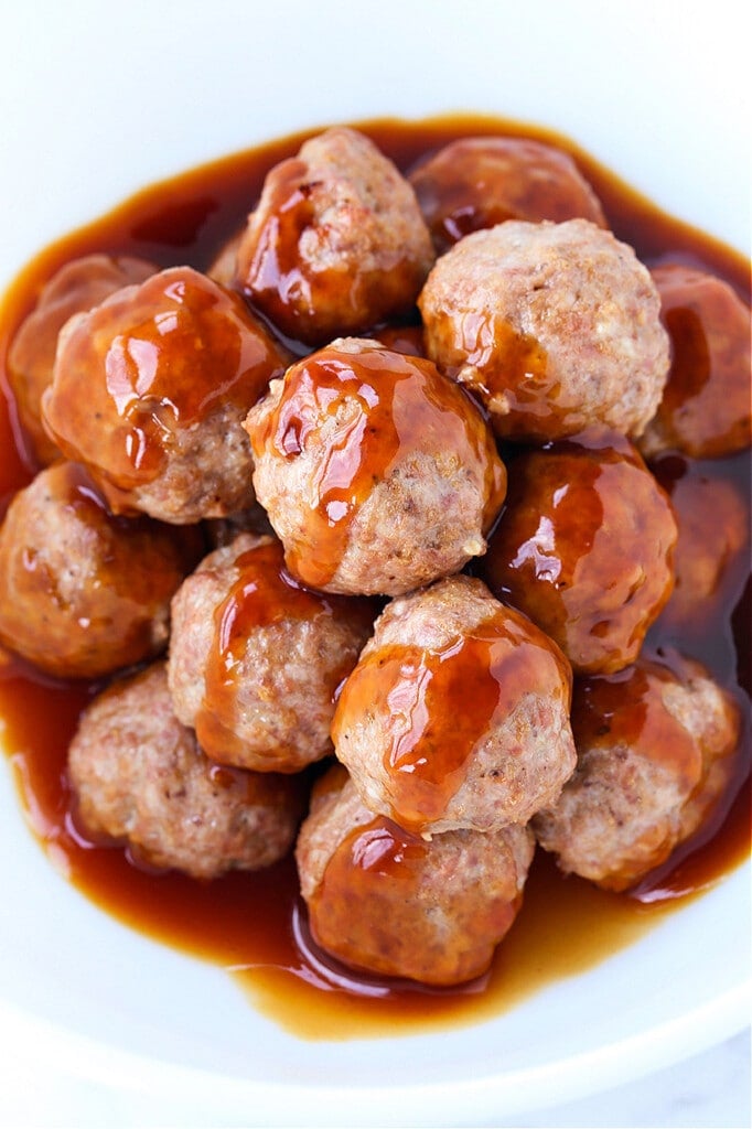 Meatballs in a white bowl with teriyaki glaze