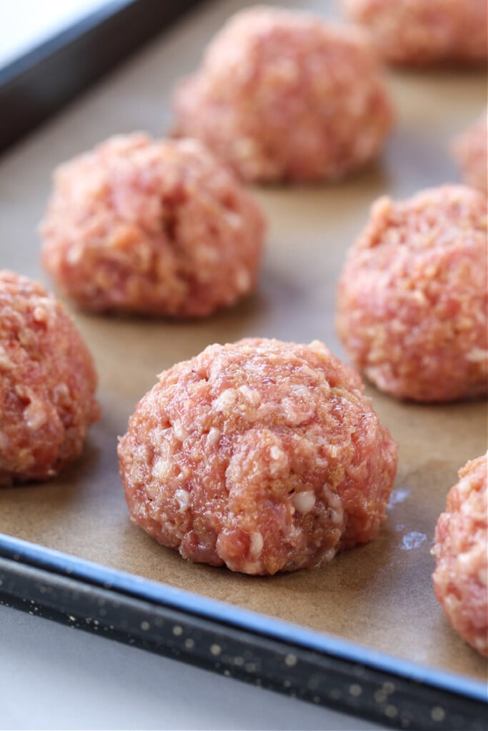This Teriyaki Meatball recipe is one of our favorite, easy to make dinners! Oven baked, flavorful meatballs tossed in a teriyaki glaze! Meatballs on a sheet pan before baking