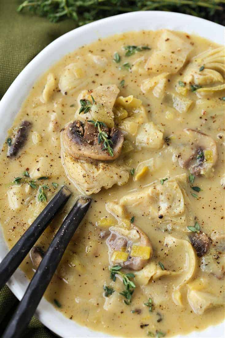 Artichoke soup in a bowl with two spoons