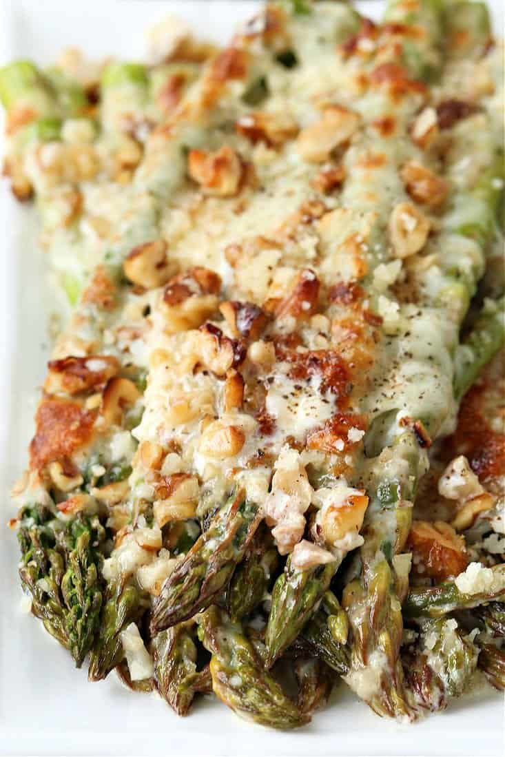 Roasted asparagus topped with cheese and walnuts