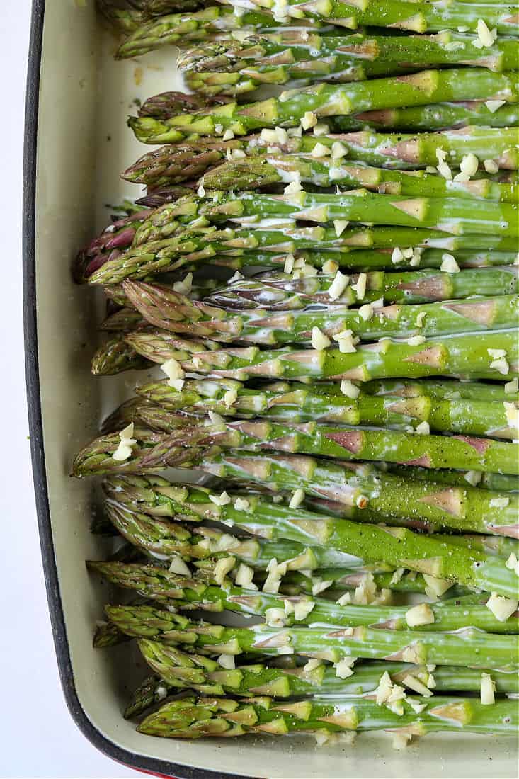 Asparagus lined up in a baking dish with cream