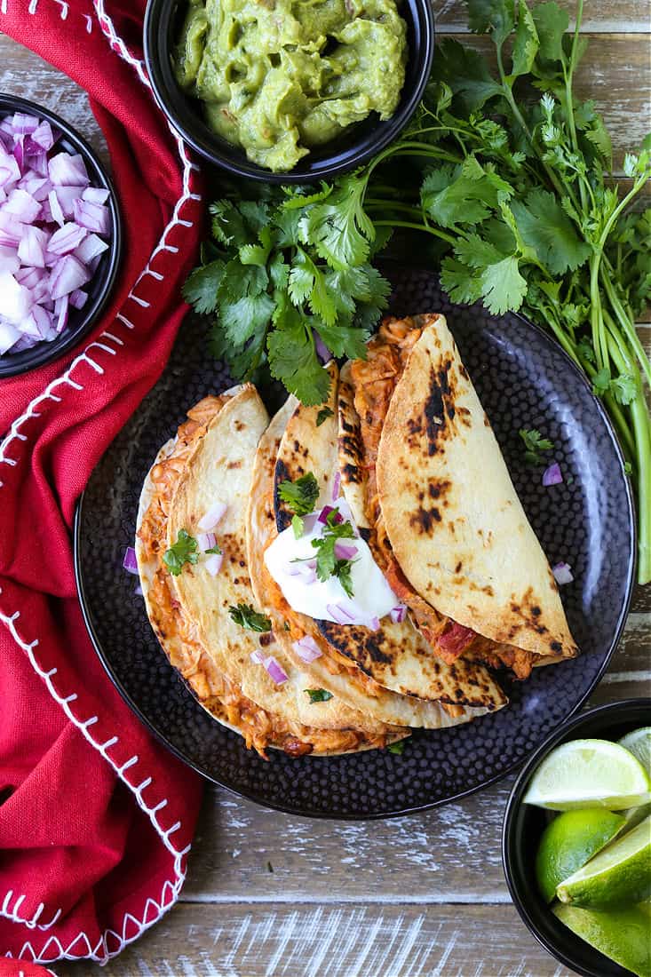 tacos on a plate with cilantro and sour cream