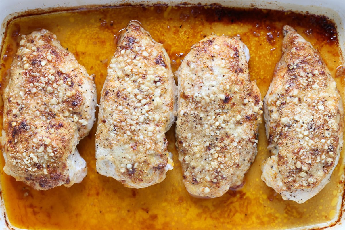 Baked Parmesan Crusted Chicken is an easy, 30 minute dinner recipe! Juicy chicken breasts baked with a tangy, parmesan crust! baked parmesan chicken breasts in baking dish