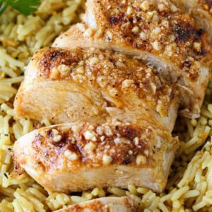 sliced parmesan crusted chicken breast on bed of rice pilaf