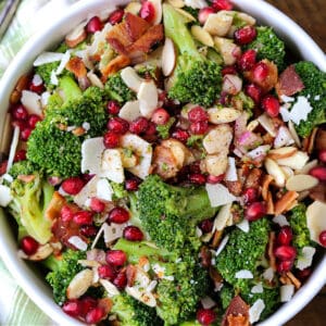 Top view of broccoli salad in a white bowl next to a cloth napkin.