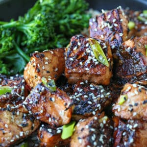 Crispy teriyaki salmon bites in a bowl with broccolini