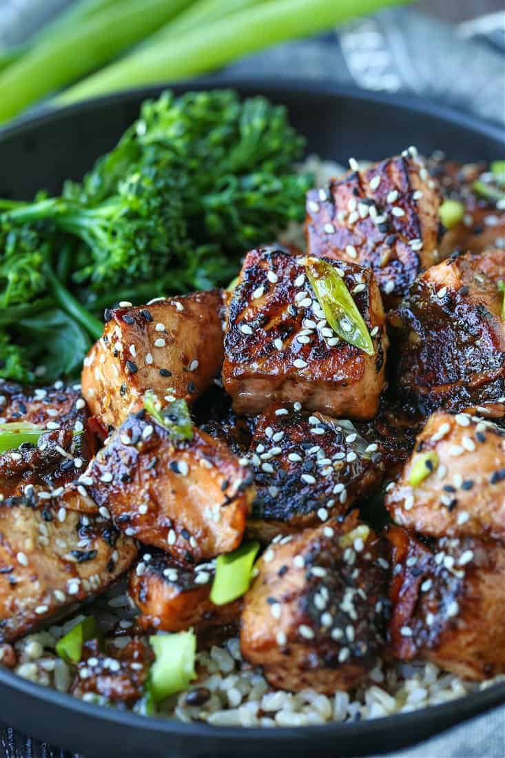 Crispy teriyaki salmon bites in a bowl with broccolini