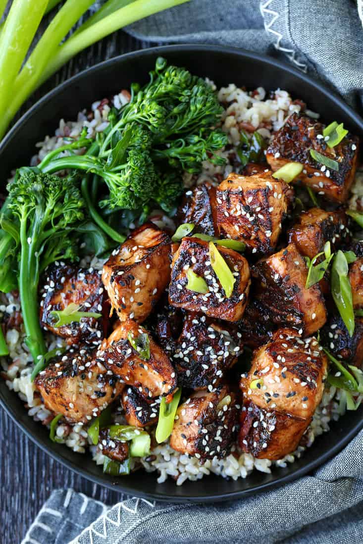 teriyaki salmon bites in a bowl with broccolini and rice