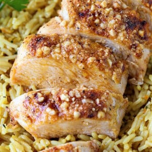 Parmesan Baked Chicken Breasts sliced on a bed of rice