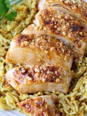 Parmesan Baked Chicken Breasts sliced on a bed of rice