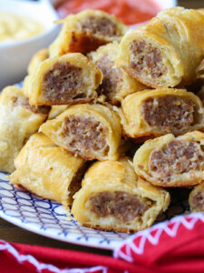 puff pastry sausage rolls stacked on plate