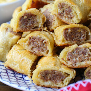 puff pastry sausage rolls stacked on plate