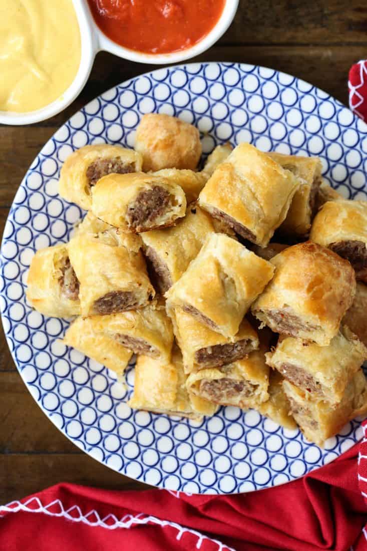 Sausage rolls cut into pieces on a plate with dipping sauce
