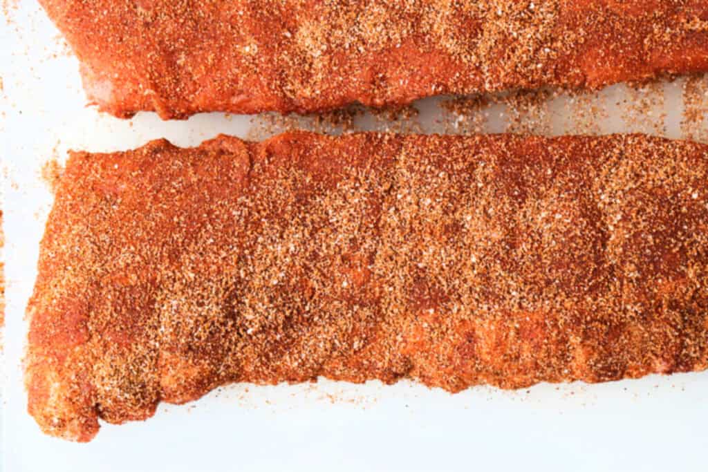 Slow Cooker BBQ Ribs couldn't be easier to make and you won't believe how amazing they turn out! An easy dinner recipe for any occasion! seasoned ribs on a cutting board