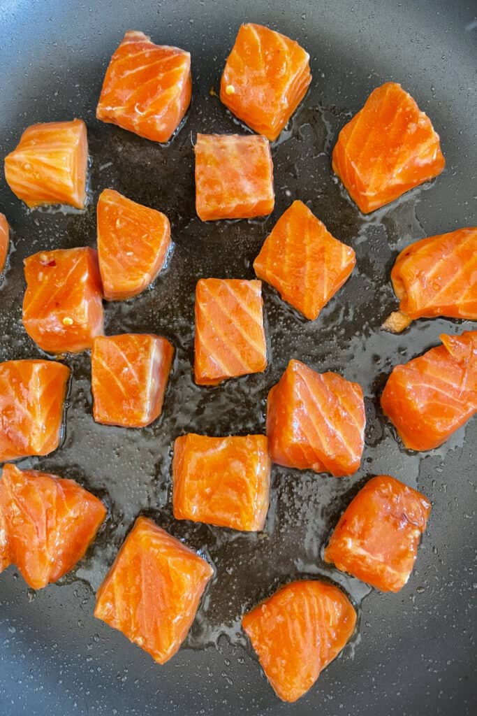 raw cubed salmon in a skillet