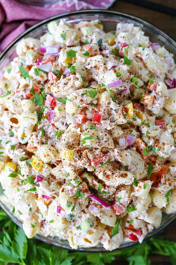 This creamy Tuna Pasta Salad is one of my favorite comfort foods! Perfect for bringing to a BBQ, potluck or for serving at any party! Tuna pasta salad in a bowl with red napkin